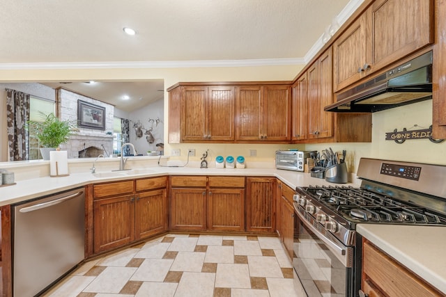 kitchen featuring brown cabinetry, appliances with stainless steel finishes, a sink, light countertops, and under cabinet range hood