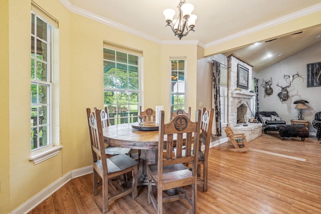 dining room with an inviting chandelier, crown molding, light wood-style flooring, and plenty of natural light