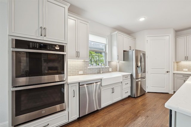 3004 Culver Ave, Celina, TX 75009 - kitchen featuring backsplash, appliances with stainless steel finishes, a sink, white cabinetry, and dark wood-type flooring