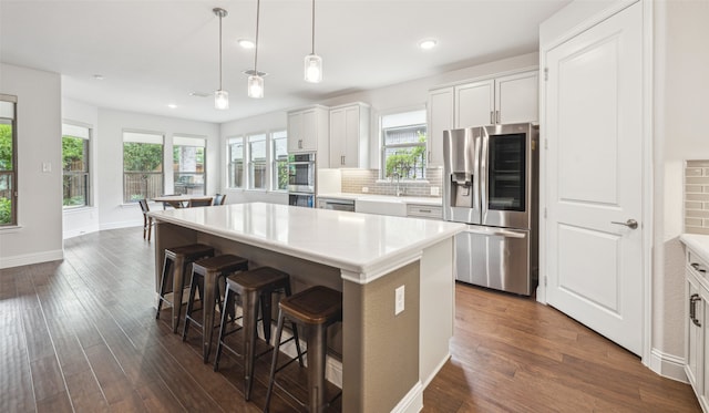 3004 Culver Ave, Celina, TX 75009 - kitchen featuring a kitchen island, appliances with stainless steel finishes, dark wood-style floors, and a breakfast bar