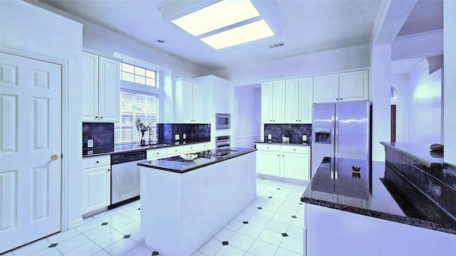 kitchen featuring a center island, appliances with stainless steel finishes, white cabinets, and tasteful backsplash