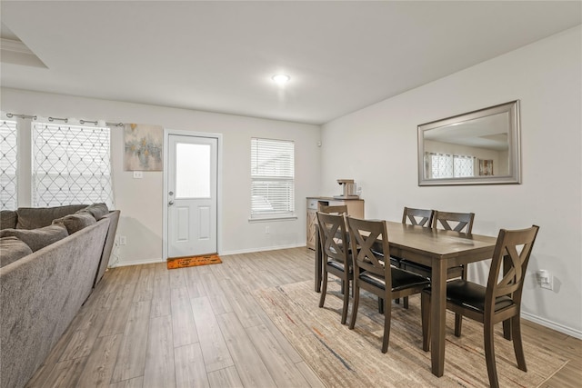 dining area featuring baseboards and light wood-style flooring