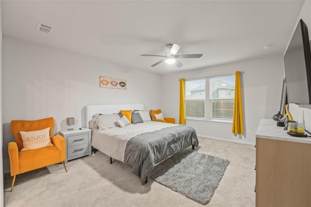bedroom featuring visible vents, a ceiling fan, baseboards, and light colored carpet
