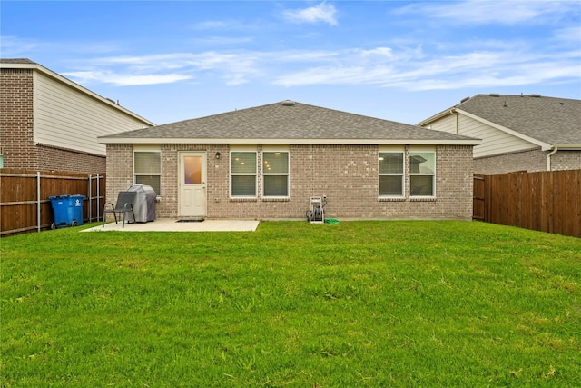 back of house with brick siding, a patio, a fenced backyard, and roof with shingles