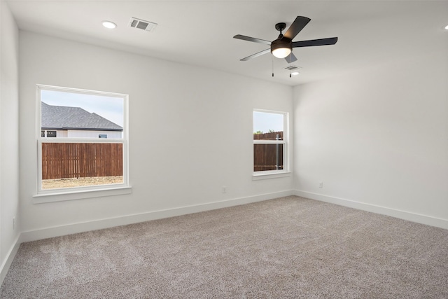 carpeted empty room featuring recessed lighting, baseboards, visible vents, and ceiling fan