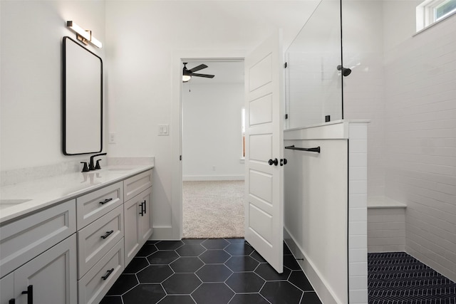 full bath with double vanity, a ceiling fan, a walk in shower, tile patterned floors, and a sink