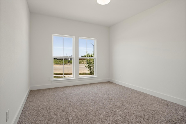 empty room with baseboards and carpet