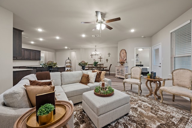 living room featuring ceiling fan with notable chandelier, recessed lighting, wood finished floors, and visible vents