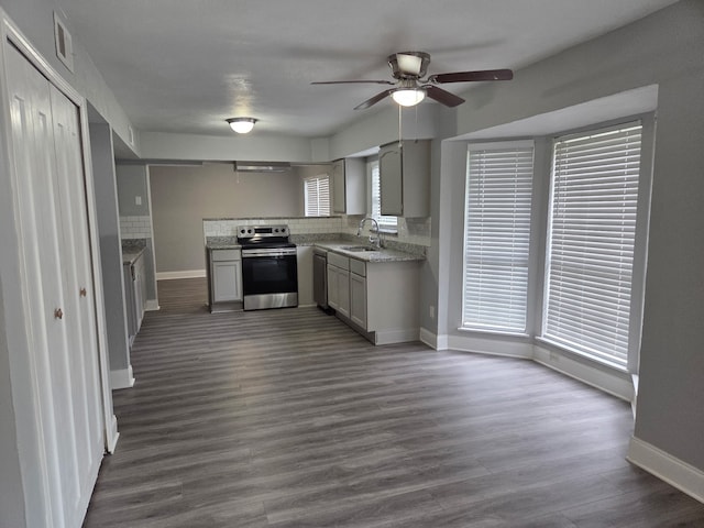 kitchen featuring ceiling fan, a sink, stainless steel appliances, baseboards, and tasteful backsplash