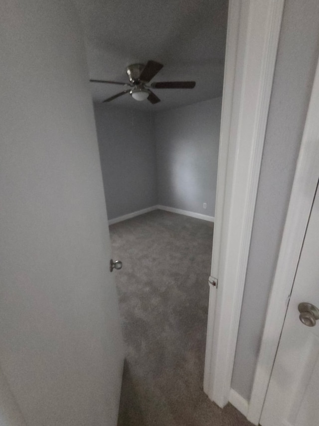 spare room featuring carpet floors, ceiling fan, and baseboards