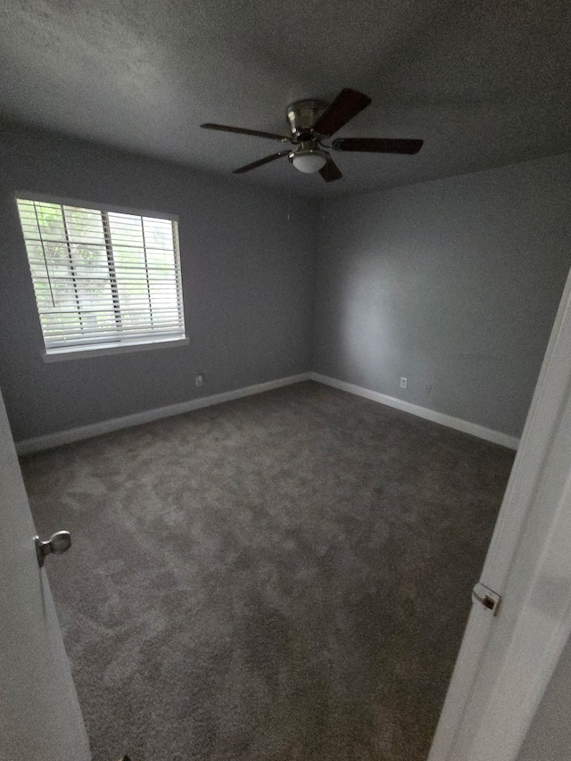 carpeted spare room featuring baseboards, a ceiling fan, and a textured ceiling