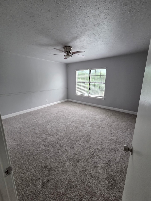 spare room featuring carpet floors, a ceiling fan, a textured ceiling, and baseboards