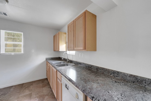 kitchen featuring visible vents, white dishwasher, dark countertops, a sink, and baseboards