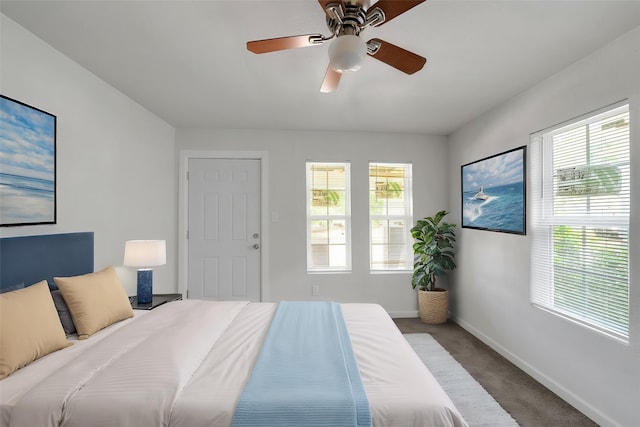 carpeted bedroom with baseboards, multiple windows, and ceiling fan