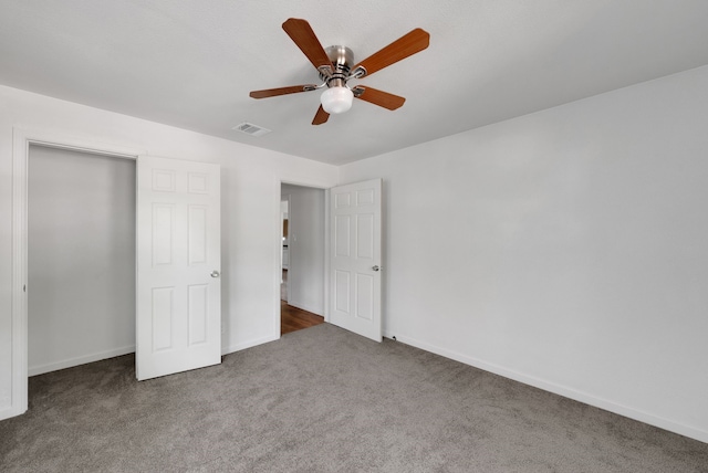 unfurnished bedroom with baseboards, carpet, a ceiling fan, and visible vents