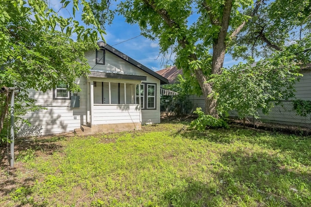 back of property featuring fence and a yard