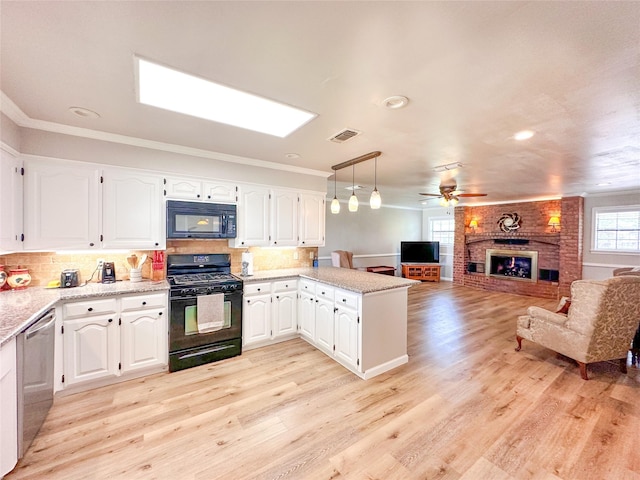 104 W Perry St, Frankston, TX 75763 - kitchen with a brick fireplace, a peninsula, open floor plan, visible vents, and black appliances