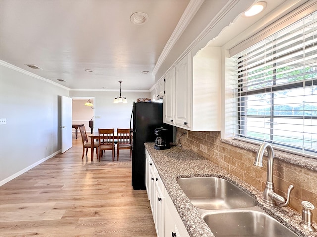 104 W Perry St, Frankston, TX 75763 - kitchen featuring a sink, light wood-style flooring, white cabinetry, backsplash, and ornamental molding
