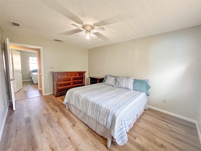 104 W Perry St, Frankston, TX 75763 - bedroom with visible vents, light wood-style floors, baseboards, a textured ceiling, and a ceiling fan