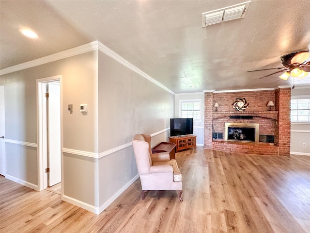 104 W Perry St, Frankston, TX 75763 - living area featuring a ceiling fan, visible vents, a brick fireplace, wood finished floors, and baseboards