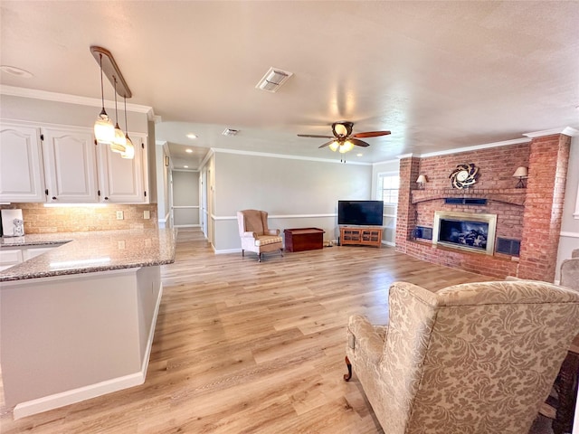 104 W Perry St, Frankston, TX 75763 - living area featuring ornamental molding, a brick fireplace, baseboards, a ceiling fan, and light wood finished floors
