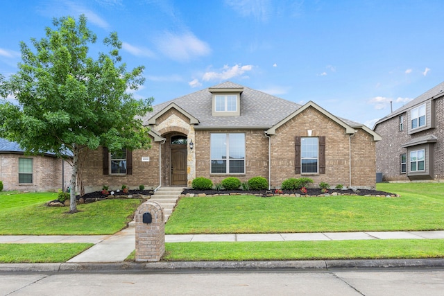 traditional-style home featuring brick siding, roof with shingles, and a front lawn