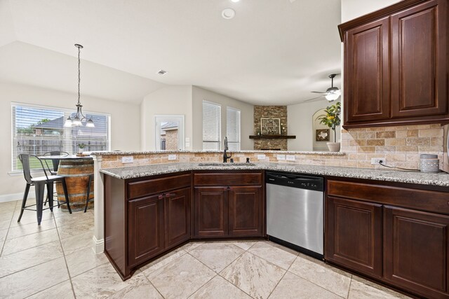 kitchen featuring lofted ceiling, tasteful backsplash, a sink, ceiling fan with notable chandelier, and dishwasher