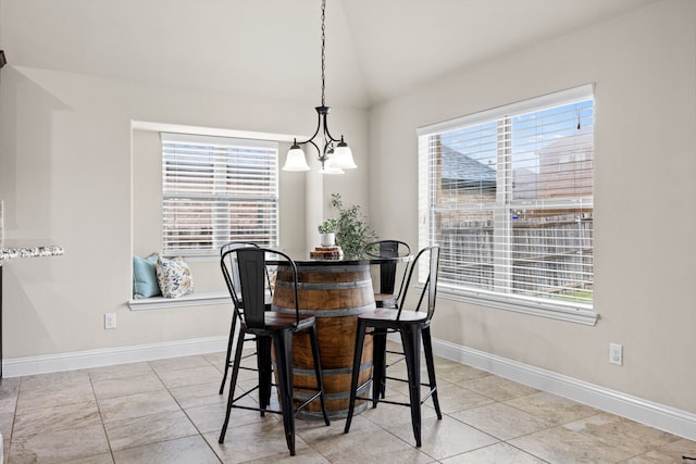 dining room with an inviting chandelier, baseboards, and vaulted ceiling