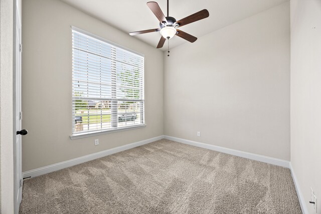 carpeted empty room with baseboards and ceiling fan
