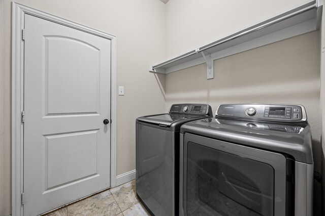 laundry room with separate washer and dryer, baseboards, and laundry area