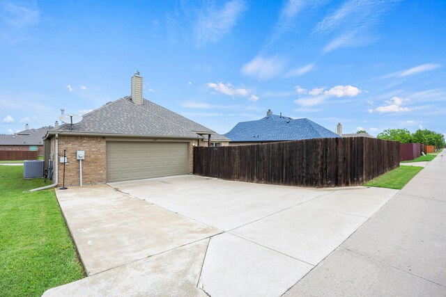 view of property exterior with a garage, central AC, fence, and concrete driveway