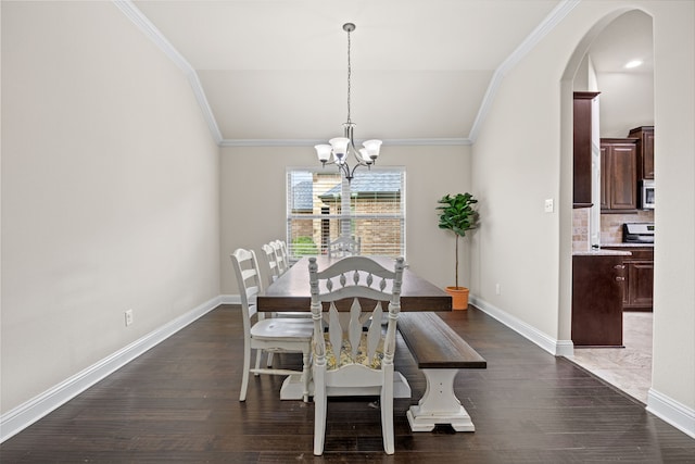 dining space featuring an inviting chandelier, arched walkways, ornamental molding, baseboards, and dark wood-style floors