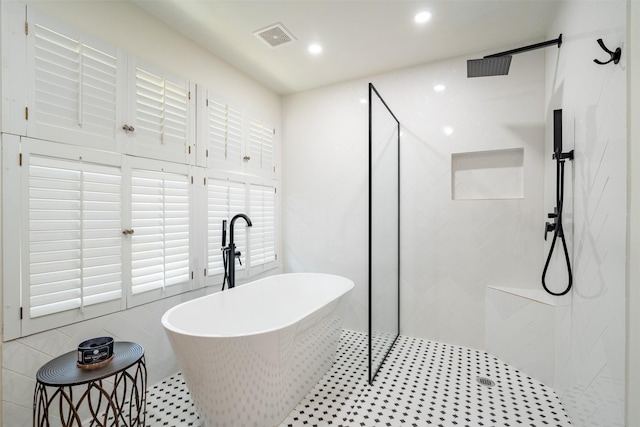 full bath with a soaking tub, walk in shower, recessed lighting, and visible vents