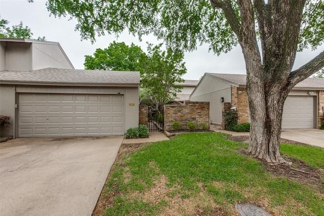 multi unit property featuring driveway, a shingled roof, a gate, and a garage