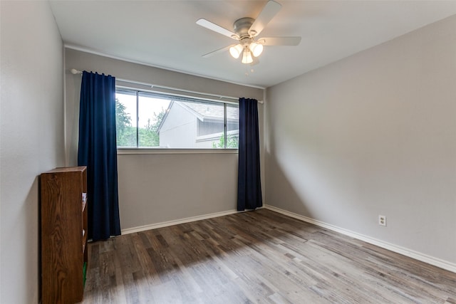 spare room with baseboards, a ceiling fan, and wood finished floors