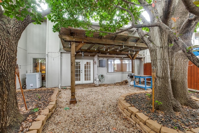 back of house featuring a pergola, fence, and french doors