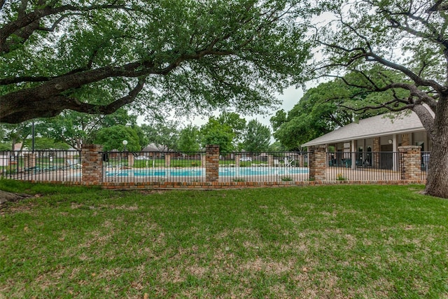 view of yard with fence and a community pool