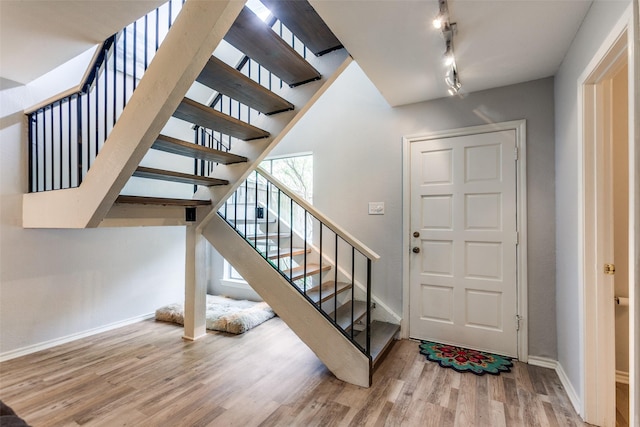 entryway featuring stairway, baseboards, and wood finished floors