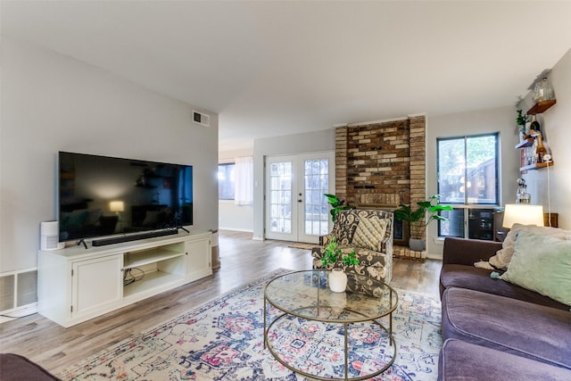 living area featuring light wood-style floors, baseboards, french doors, and visible vents