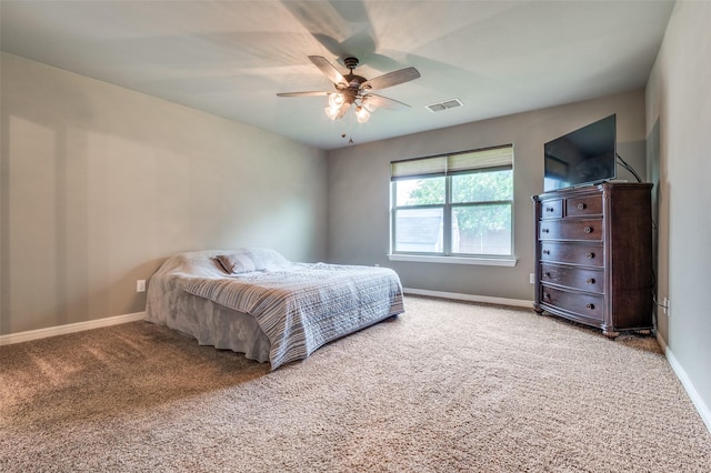 carpeted bedroom with baseboards, a ceiling fan, and visible vents