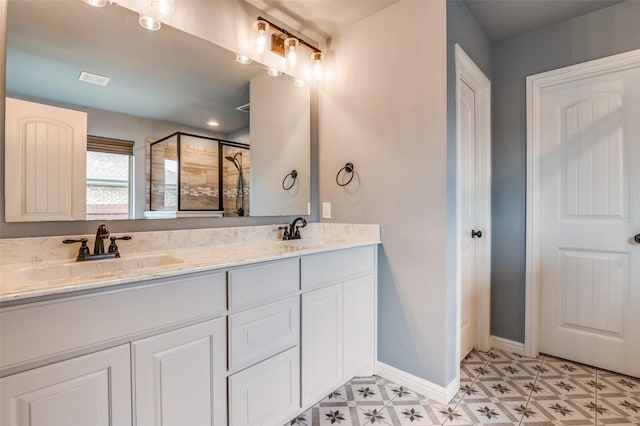 full bath with a sink, baseboards, a stall shower, and double vanity