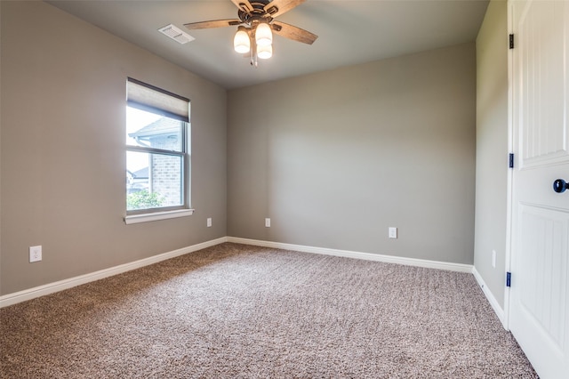 carpeted empty room with baseboards, ceiling fan, and visible vents