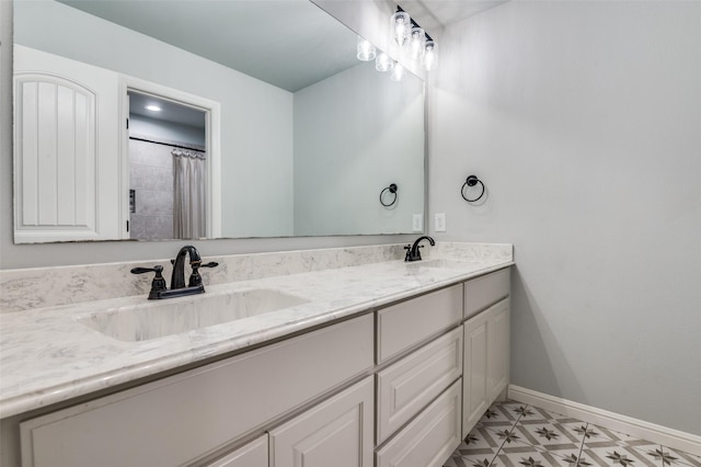 bathroom featuring a sink, baseboards, tile patterned floors, and double vanity