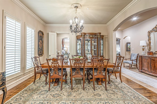 4230 Indian Creek Ln, Frisco, TX 75033 - dining space featuring crown molding, arched walkways, a notable chandelier, and wood finished floors
