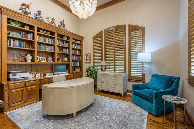 office area with crown molding, built in desk, a notable chandelier, and dark wood-style floors