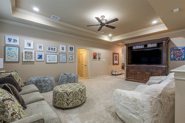 living area with a ceiling fan, visible vents, crown molding, a raised ceiling, and light carpet