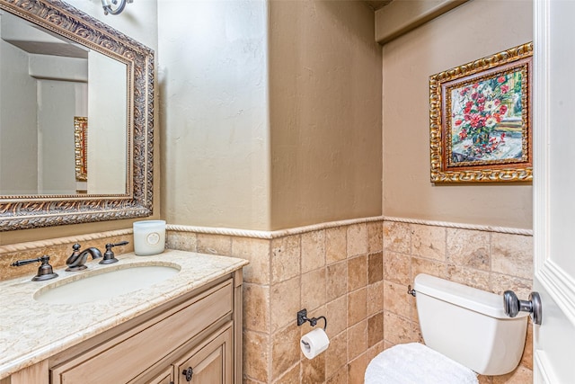 4230 Indian Creek Ln, Frisco, TX 75033 - half bathroom with tile walls, toilet, wainscoting, and vanity