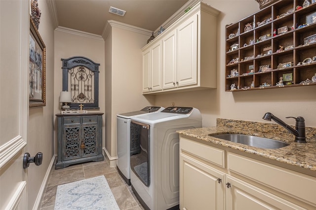 laundry room featuring crown molding, washer and dryer, baseboards, a sink, and cabinet space