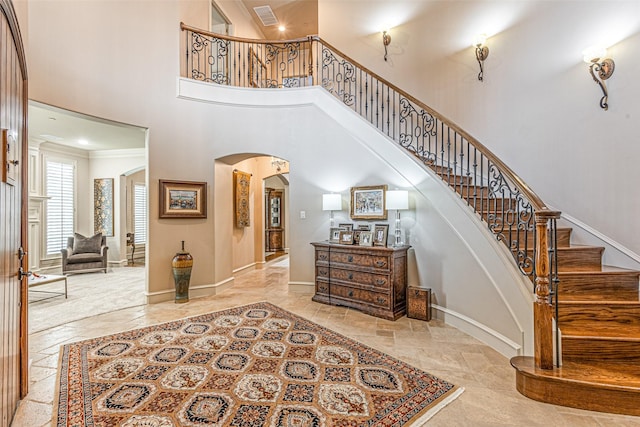 4230 Indian Creek Ln, Frisco, TX 75033 - entryway featuring arched walkways, a towering ceiling, baseboards, stairs, and crown molding