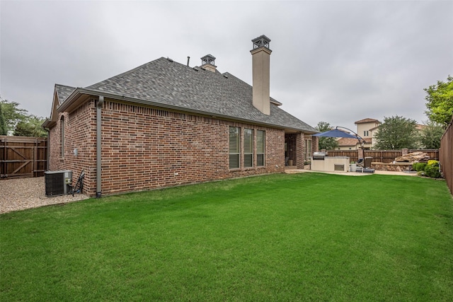 rear view of house featuring a fenced backyard, a patio area, central AC, and brick siding